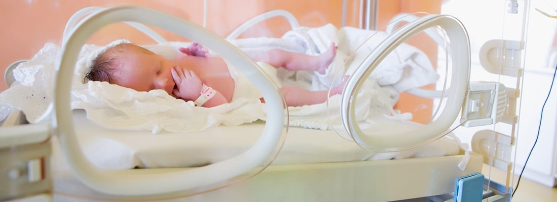 Baby asleep in Incubator in hospital unit