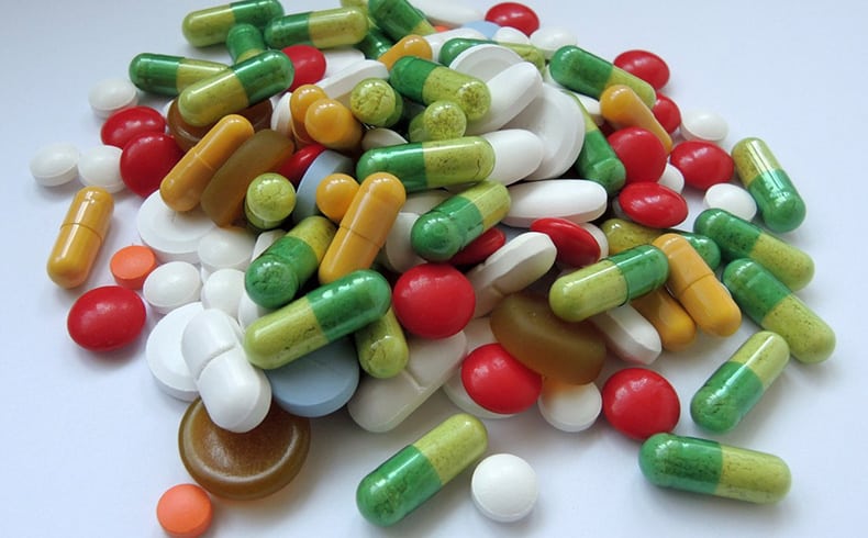 Large group of colourful tablets sitting on a white background