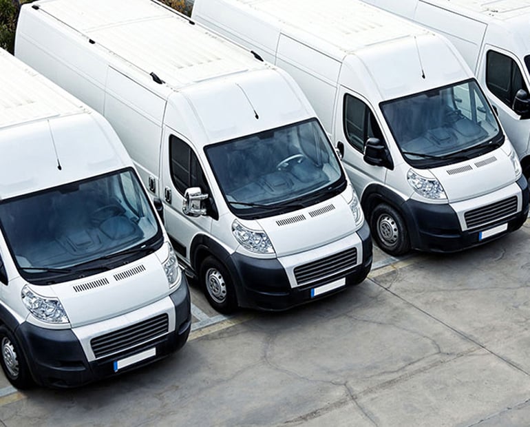 Four white vans lined up 