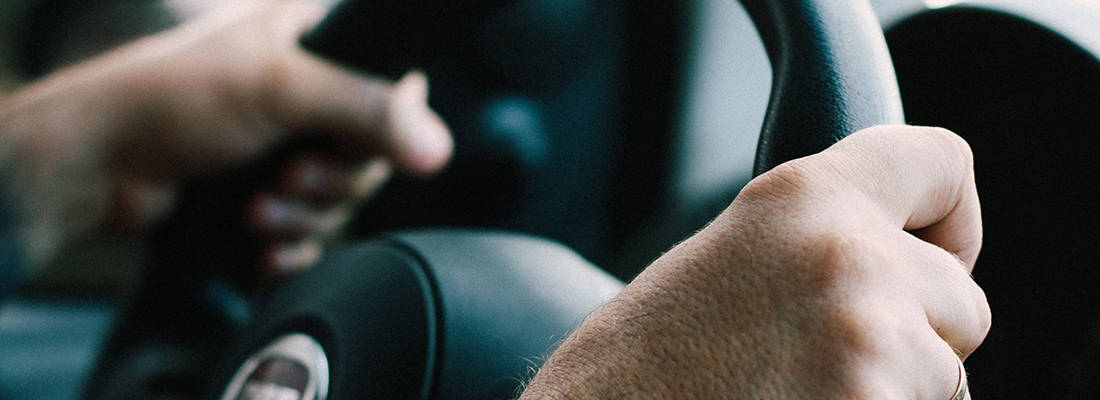 Close up of hands gripping a steering wheel 