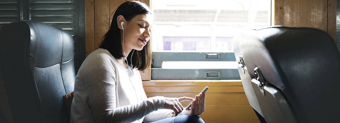 Female wearing earphones sitting on a train 