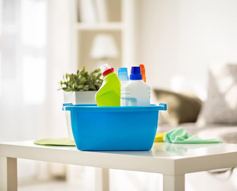 Blue Bucket of cleaning products sitting on white table