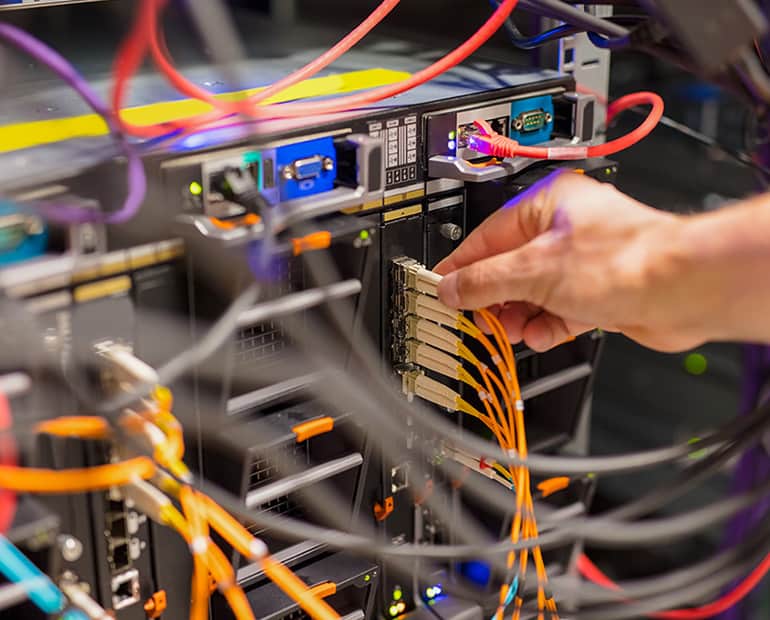 Network cables leading into the back of a server 