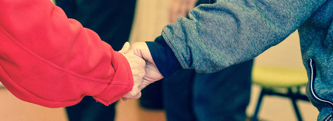 Elderly couple hold hands 