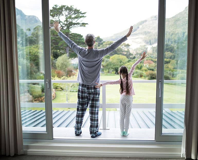 Father and Daughter looking at view of mountains from balcony 