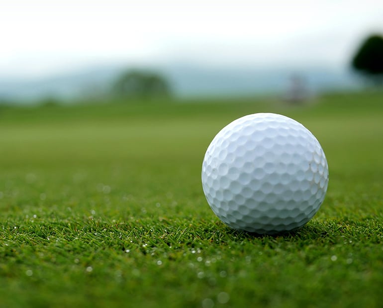 Close up of golf ball sitting on green 