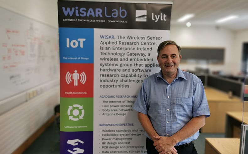 Stephen Seawright, Technology Gateway Manager at WiSAR standing in front of a WiSAR banner