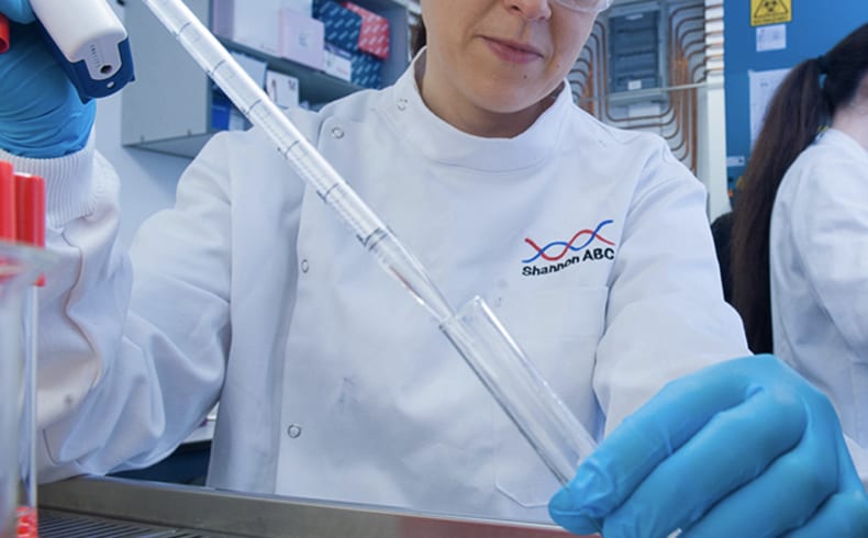 Female researcher wearing white lab coat working in lab