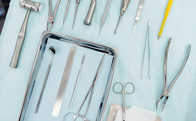 Close up of surgery tools on a light blue cloth
