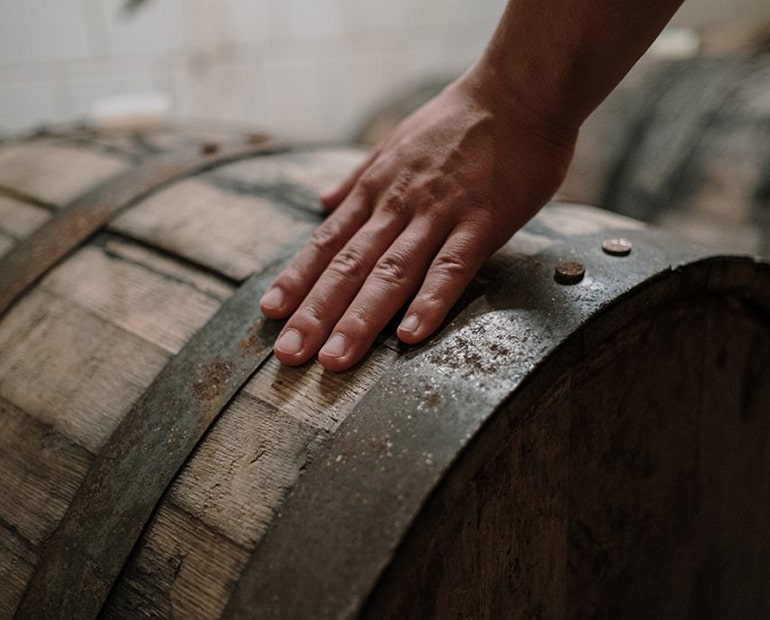 Hand on whiskey barrel 
