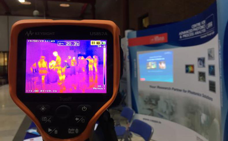 A Scientific grade InfraRed (IR) thermography camera points at conference attendees. To the right sits a CAPPA stand. 
