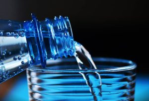 bottle of water poured into a glass