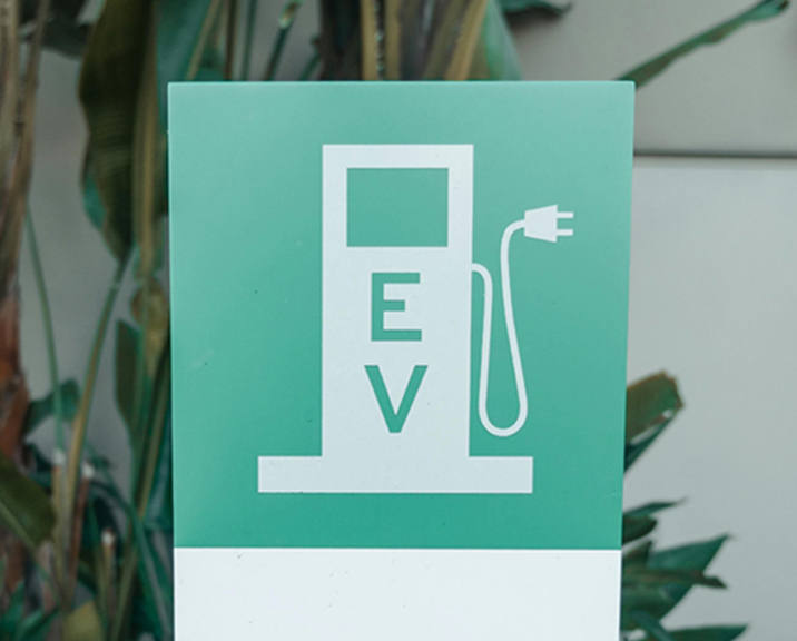 Green sign with EV charger graphic