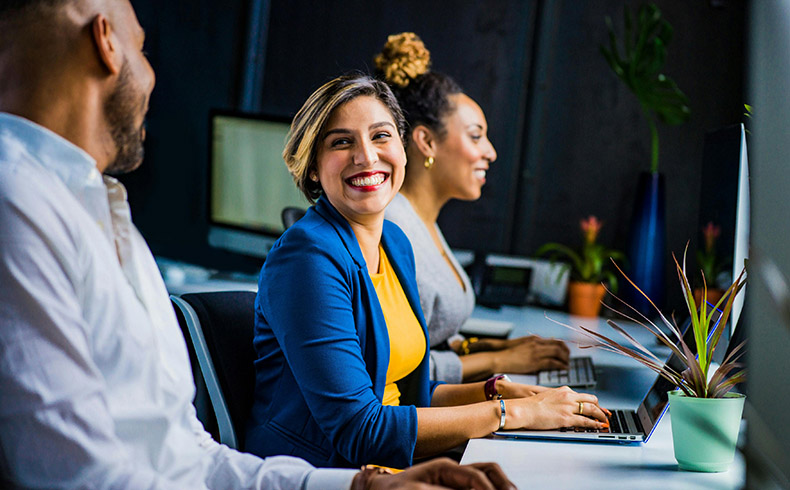 Woman in Blue Suit Jacket, taking to two co-workers