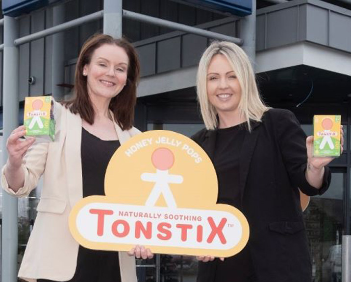 Tonstix founders holding a Tonstix sign and product