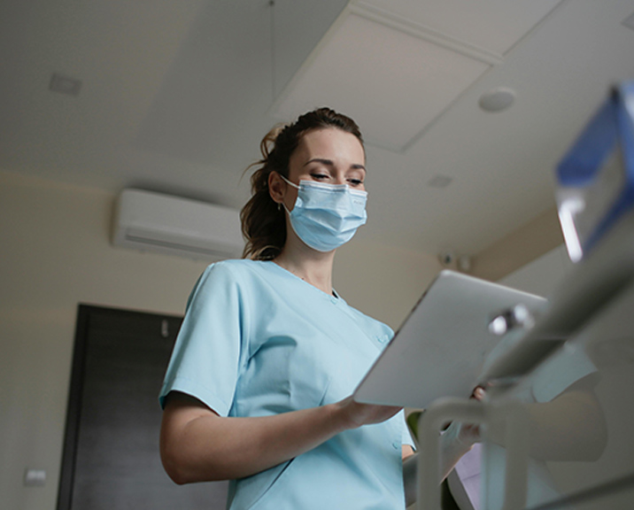 Woman in blue medical scrubs and mask
