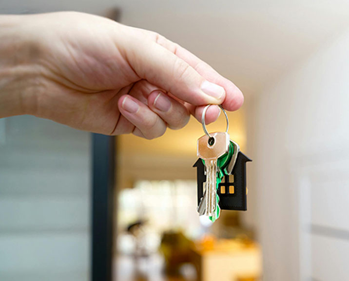 Close up of hand holding a set of house keys at a front door